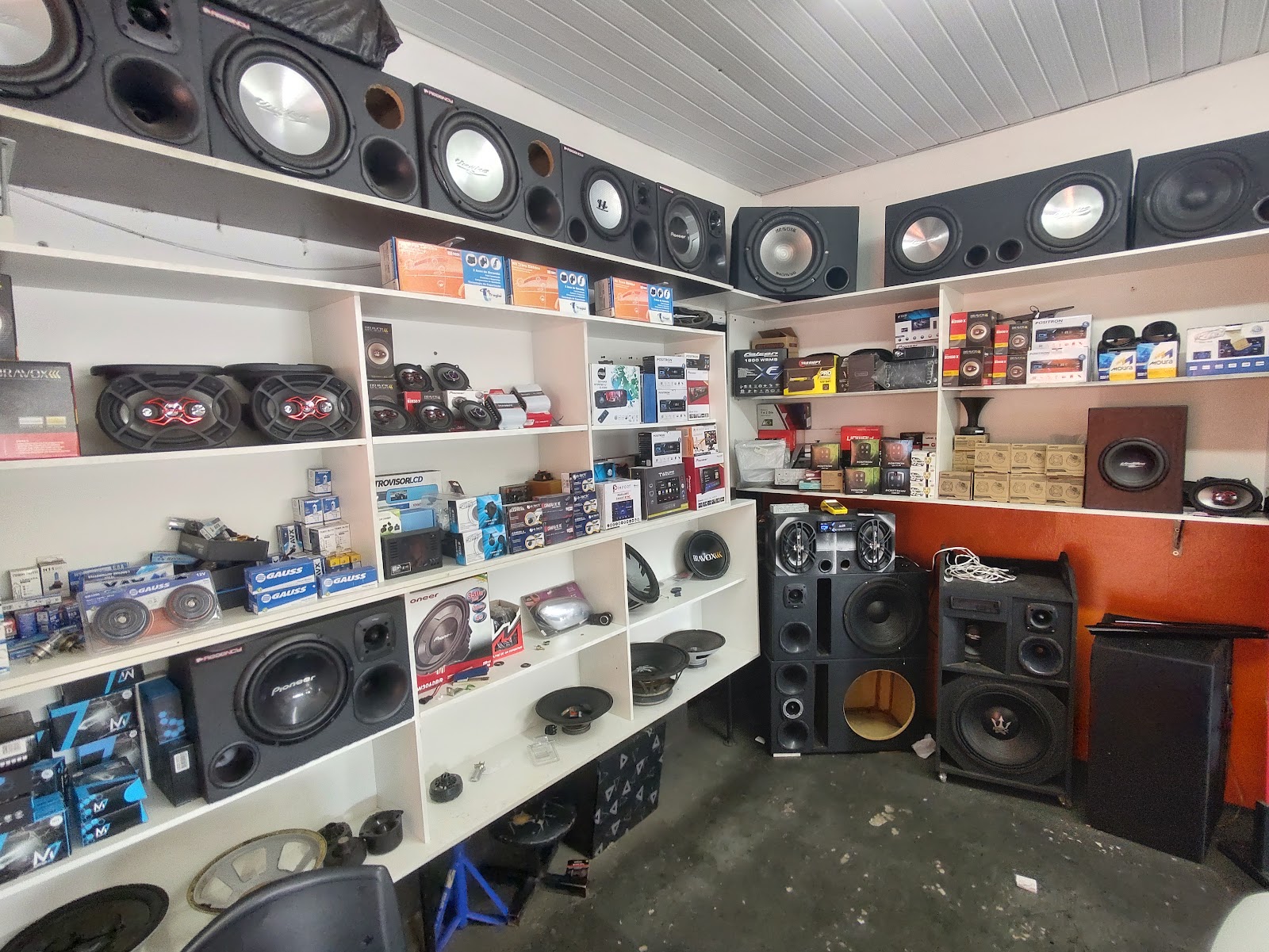 Canto da loja com prateleiras de alto-falantes, subwoofers e caixas de som