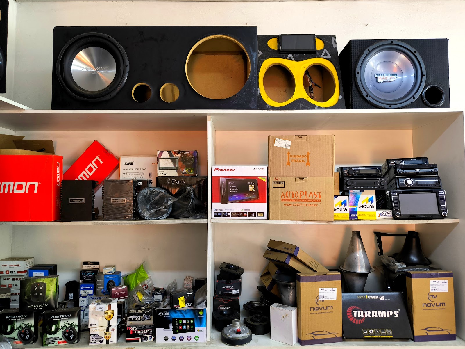 Prateleira com caixas de produtos, centrais multimídia, módulos e subwoofers