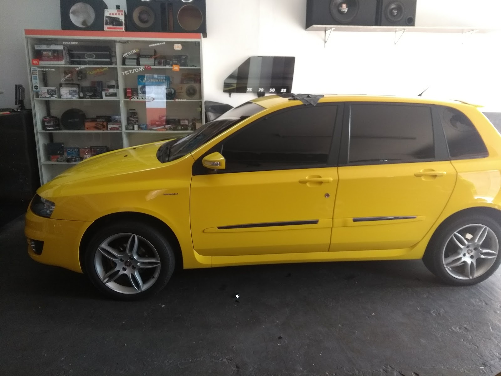Hatch amarelo com vidros escurecidos dentro da loja